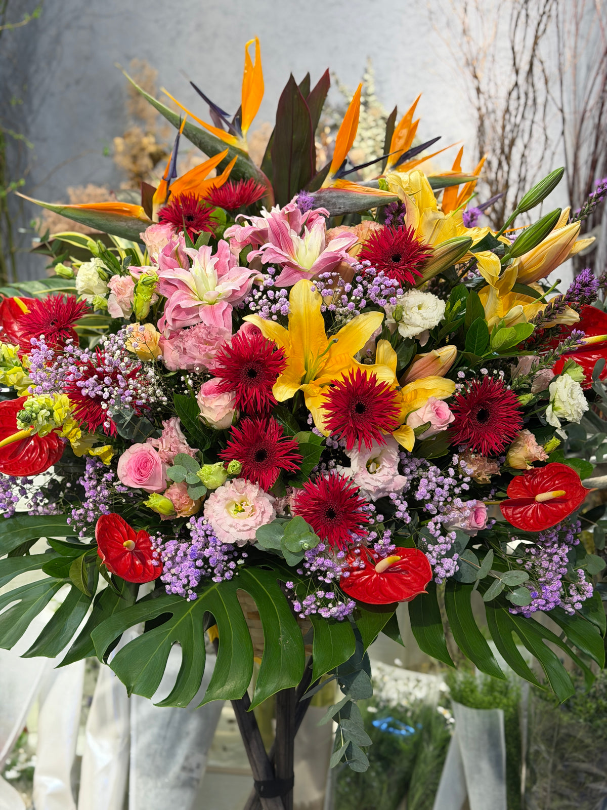花點時間 Reflower 喜慶大氣開張花籃,以天堂鳥、黃百合、粉百合為主體,配搭紅太陽菊與紅掌,底部襯以龜背葉,祝賀新店生意興隆。