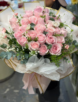 Reflower HK elegant bouquet featuring 28 soft pink roses and baby's breath, luxuriously wrapped in Korean-style gold-edged white paper and wavy organza.