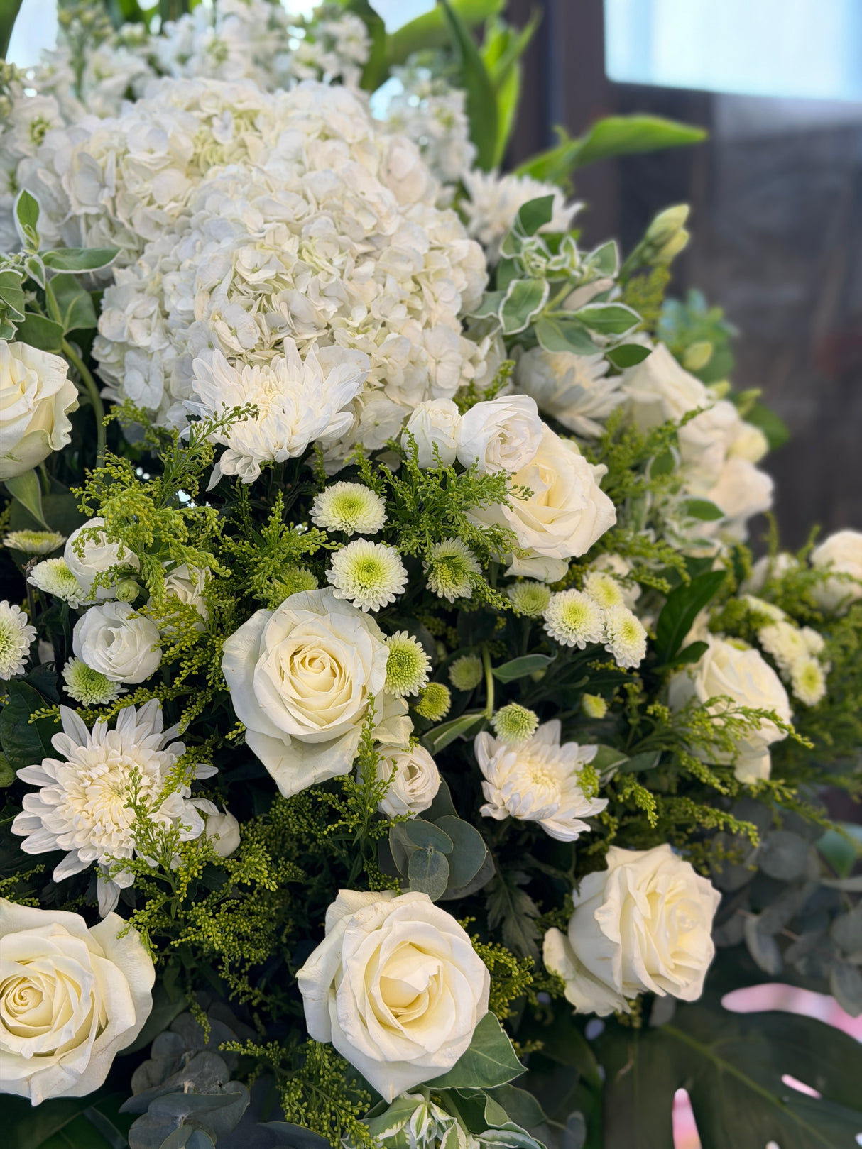 Reflower HK elegant sympathy flower stand featuring a white hydrangea, white roses, and green chrysanthemums, designed for funeral homes and memorial services to express deepest condolences.