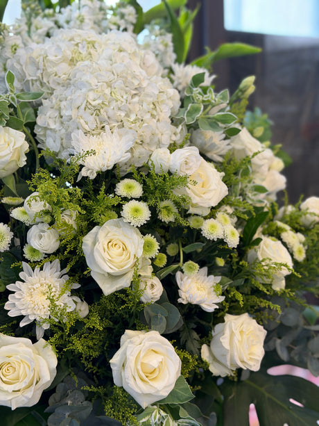 Reflower HK elegant sympathy flower stand featuring a white hydrangea, white roses, and green chrysanthemums, designed for funeral homes and memorial services to express deepest condolences.