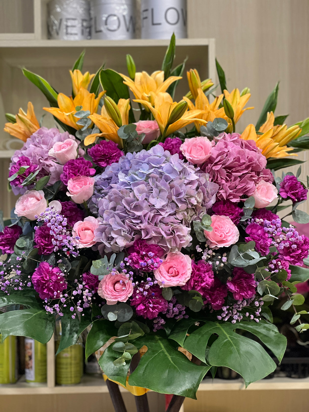 花點時間 Reflower 鴻圖大展粉紅百合配紅太陽菊開張花籃，底襯大型翠綠龜背葉，大氣豐滿，適合新店開張及寫字樓喬遷祝賀。