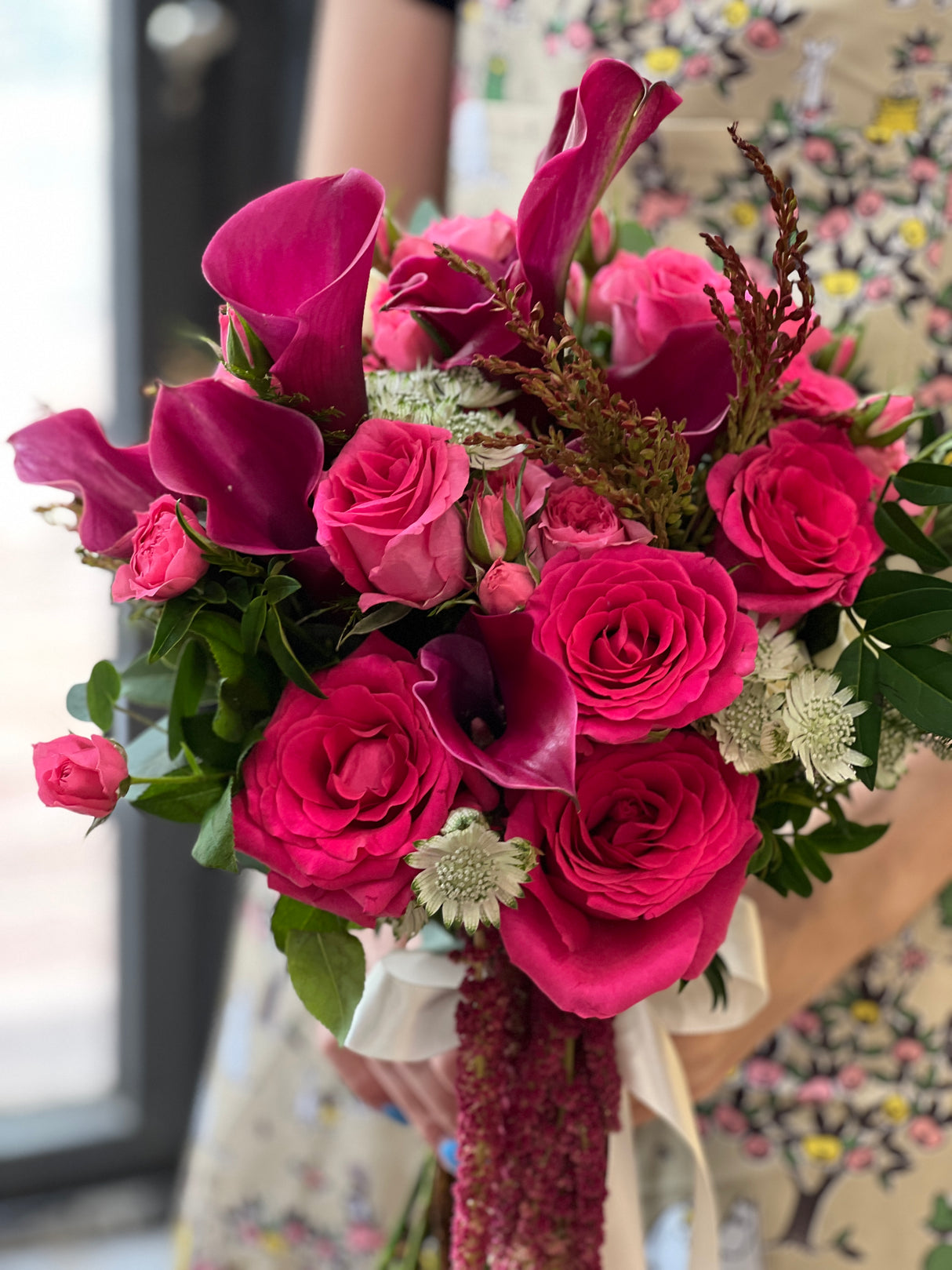 Reflower HK bold and elegant bridal bouquet featuring jewel-toned magenta calla lilies, hot pink roses, and astrantia, matched with a groom's boutonniere for a modern wedding style.