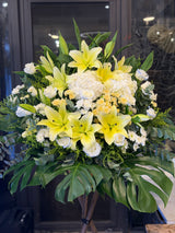 花點時間 Reflower 浩氣長存黃百合與白繡球素雅帛事花牌，特別配搭冰清玉潔的冰藍玫瑰、菊花與龜背葉，配色莊重溫暖，適合送往殯儀館及教會表達哀悼。