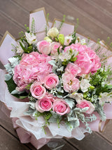 Reflower HK dreamy romantic bouquet featuring a pink hydrangea, pink roses, and Dusty Miller, luxuriously wrapped in Korean-style gold-edged pink paper and wavy organza.