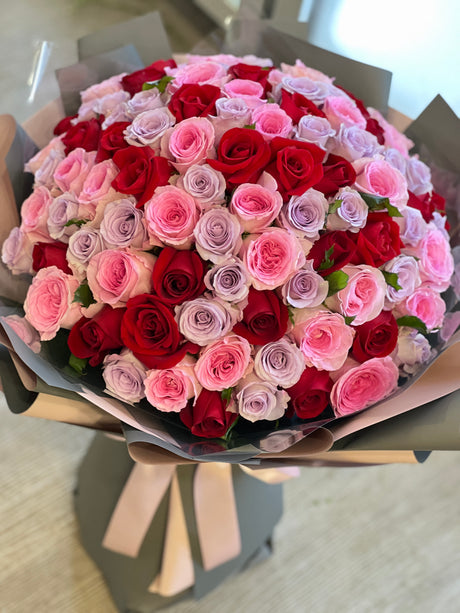 Reflower HK stunning giant proposal bouquet featuring 99 premium red, pink, and lavender roses, wrapped in luxurious dark grey and nude paper.