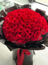 花點時間 Reflower 永恆摯愛 99 枝頂級紅玫瑰求婚巨型花束，採用極具現代奢華感的純黑霧面包裝與紅色絲帶，強烈對比展現霸道深情。