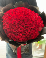 Reflower HK ultimate proposal bouquet featuring 99 premium red roses, strikingly wrapped in modern matte black paper with a red ribbon for a luxurious contrast.