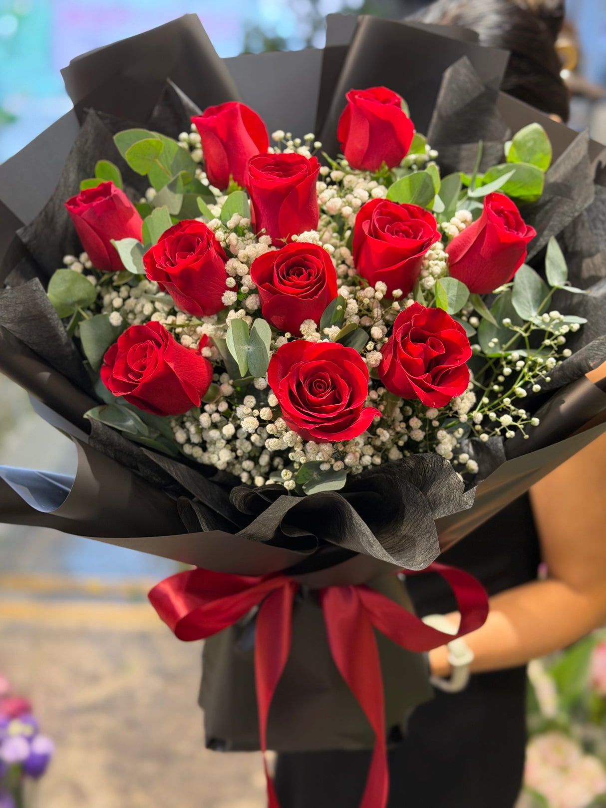 Reflower HK modern romantic bouquet featuring 11 premium red roses and baby's breath, strikingly wrapped in matte black paper with a red ribbon for a luxurious contrast.