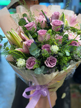 Reflower HK elegant bouquet featuring purple roses, pink lilies, and white scabiosa, wrapped in nude-pink paper with a light purple ribbon.
